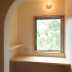 フローリングの客室の窓辺には本棚があり読書を楽しめる 客室に備え付けられた明るい読書机