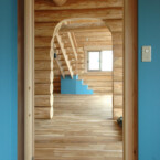 この家のアクセントカラーになっている空をイメージした青。階段下収納(一番奥)にも塗られている。 部屋から玄関、階段のあるLDKをみる